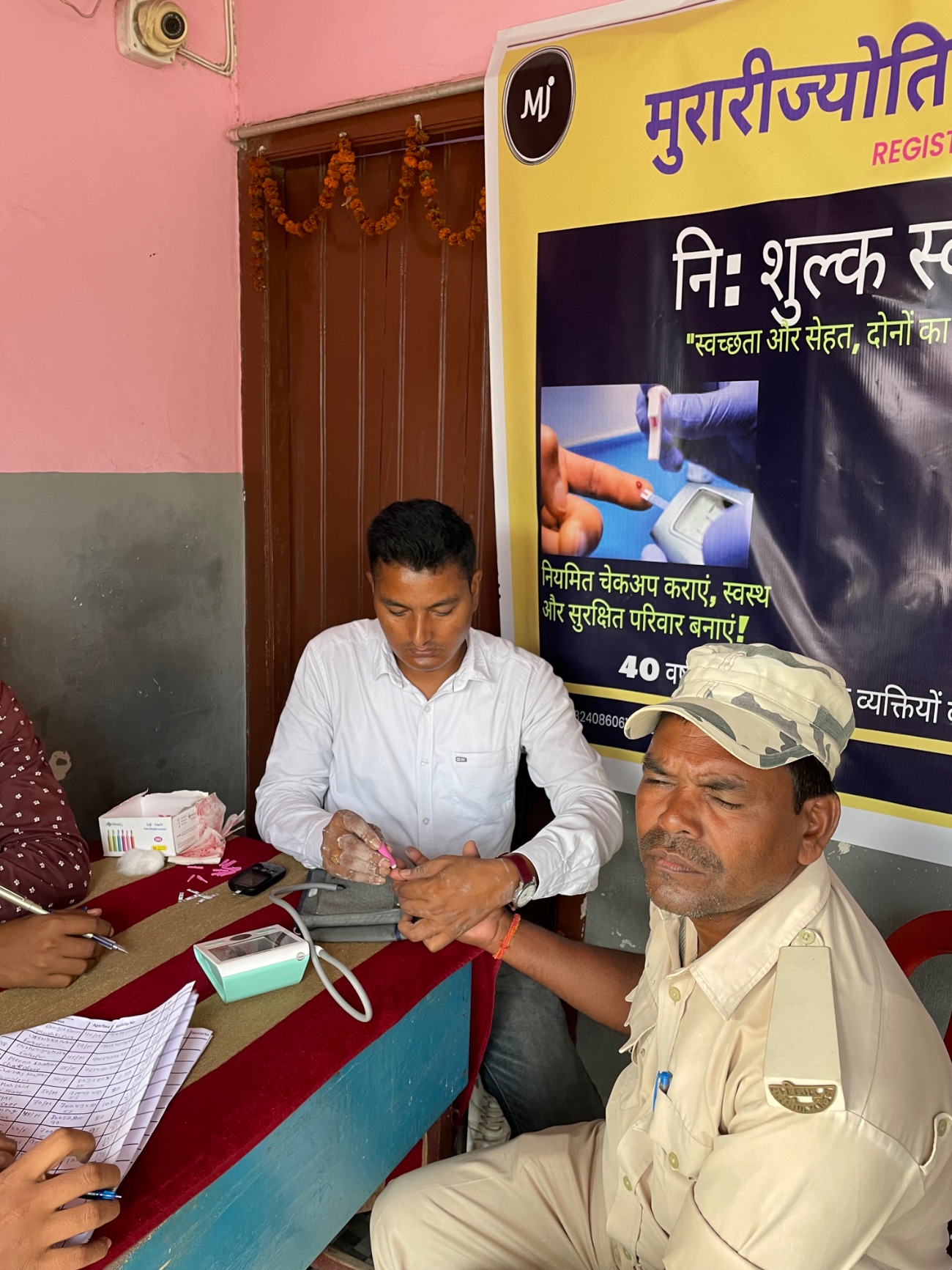 A man has his blood sugar checked with a finger-prick test at a free MJWF community health camp.