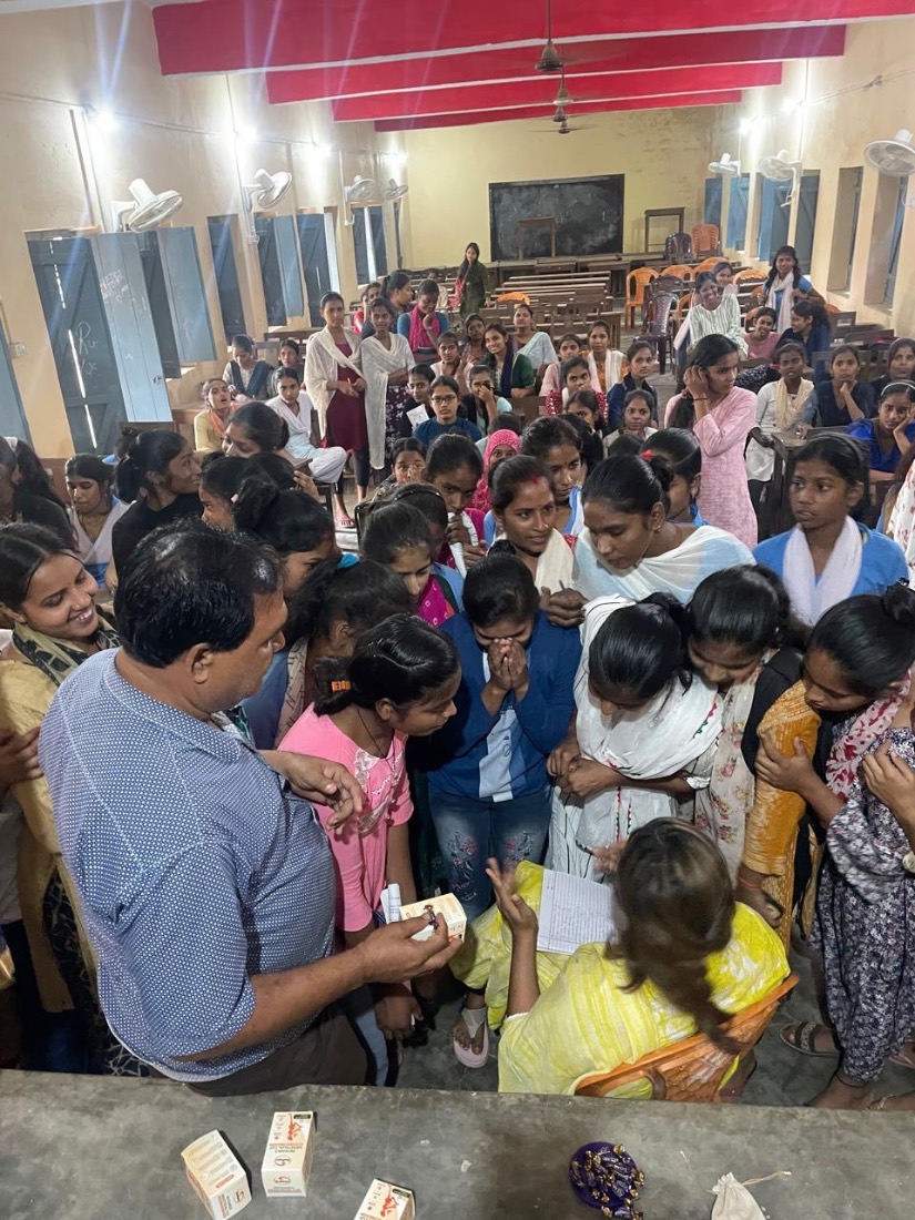 Girls gather closely around an MJWF facilitator during a one-to-one guidance session.